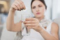 Sick pregnant woman sitting at home on the couch. She throws two tablets into a glass of water