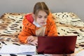 A sick quarantined girl learns remotely using a laptop