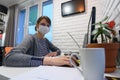 A sick quarantined girl in self-isolation at home works remotely in a computer