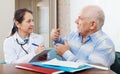 Sick senior man complaining to doctor about malaise