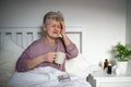 Sick senior woman in bed at home, headache and illness concept. Royalty Free Stock Photo