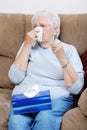 Sick senior woman blowing her nose Royalty Free Stock Photo