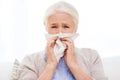 Sick senior woman blowing nose to paper napkin Royalty Free Stock Photo