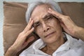 Sick senior woman lying in bed suffering from insomnia headache,touching temple with her hands,painful in the head,physical health Royalty Free Stock Photo