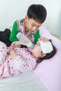 Sick sister lying and suck up milk on the bed, kindly brother keep vigil over a sick of closely.