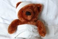 Sick teddy with injury in bed Royalty Free Stock Photo