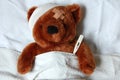 Sick teddy with injury in bed Royalty Free Stock Photo