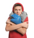 Sick teenage boy with hot water bottle on white background Royalty Free Stock Photo
