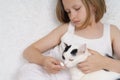 Sick teenage girl feeds a pill to a cat