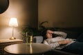 Sick tired beautiful young woman lying on a sofa in a dark room