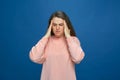 Sick tired young girl suffer headache unbearable migraine, massage temples on blue background. Flu or long covid symptom Royalty Free Stock Photo