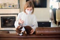 Sick toddler girl in medicine mask making vaccination her teddy bear with syringe