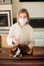 Sick toddler girl in medicine mask making vaccination her teddy bear with syringe