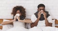 Sick african-american couple blowing noses in bed Royalty Free Stock Photo