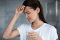 Sick unhappy woman suffering from headache, holding pill, touching forehead Royalty Free Stock Photo