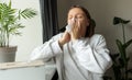 Sick unhealthy woman sneezes in paper tissue for cold, sinusitis, allergies or winter virus at home. Female with labial