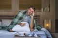 Sick wasted and exhausted man at home bed lying feeling unwell suffering cold and flu sneezing nose with tissues having virus and Royalty Free Stock Photo