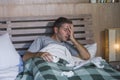 Sick wasted and exhausted man at home bed lying feeling unwell suffering cold and flu sneezing nose with tissues having virus and Royalty Free Stock Photo