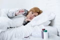 sick woman in bed checking temperature with thermometer feverish weak suffering cold winter flu virus Royalty Free Stock Photo