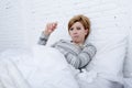 sick woman in bed checking temperature with thermometer feverish weak suffering cold winter flu virus Royalty Free Stock Photo