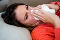 sick woman blowing her nose into a tissue Royalty Free Stock Photo