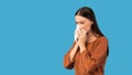 Sick Woman Blowing Runny Nose In Paper Tissue, Blue Background Royalty Free Stock Photo