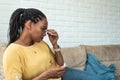 Sick woman checking the result of the thermometer. Business African American female at home measuring body temperature with Royalty Free Stock Photo