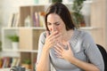 Sick woman coughing or wheezing sitting at home