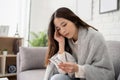 Sick woman covered in blanket sitting on sofa. She felt a severe headache and carried a pill capsule at home. Cold or fever side Royalty Free Stock Photo