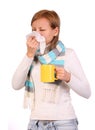 Sick woman with cup of tea sneezing in tissue isolated