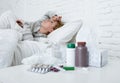 sick woman feeling bad ill lying on bed suffering headache winter cold and flu virus having medicines Royalty Free Stock Photo