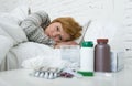 sick woman feeling bad ill lying on bed suffering headache winter cold and flu virus having medicines Royalty Free Stock Photo