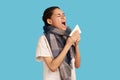 Sick woman feels unwell, sneezing in tissue, suffers from running nose, cold symptoms or allergy Royalty Free Stock Photo