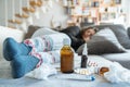 Sick woman with flu, cold, fever or virus sitting on sofa at home Royalty Free Stock Photo