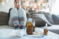 Sick woman with flu, cold, fever or virus sitting on sofa at home Royalty Free Stock Photo