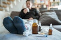 Sick woman with flu, cold, fever or virus sitting on sofa at home Royalty Free Stock Photo