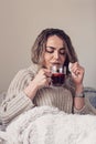 Sick Woman. Flu. Woman Caught Cold. Sitting on the Sofa. Headache. Virus. young girl covered in a blanket on a cold day enjoying Royalty Free Stock Photo