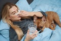 Ill female lying in bed with her sad pet Royalty Free Stock Photo