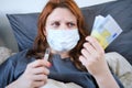 A sick woman holds a Euro and a thermometer in her hands. Money for the treatment of a girl with the flu Royalty Free Stock Photo