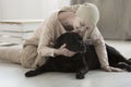 Sick woman kissing black dog