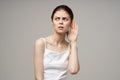 sick woman poor hearing disorders in white t-shirts light background