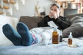 Sick woman with flu, cold, fever or virus sitting on sofa at home Royalty Free Stock Photo