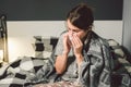 Sick woman with runny nose, sitting in bed. woman feeling unwell and sneeze bedroom. Woman holding tissue ,flu symptoms Royalty Free Stock Photo