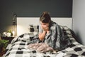 Sick woman with runny nose, sitting in bed. woman feeling unwell and sneeze bedroom. Woman holding tissue ,flu symptoms Royalty Free Stock Photo