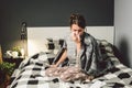 Sick woman with runny nose, sitting in bed. woman feeling unwell and sneeze bedroom. Woman holding tissue ,flu symptoms Royalty Free Stock Photo