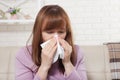 Sick woman sitting at home with high fever. Cold, flu, fever and migraine, sneeze. Copy space. Runny nose