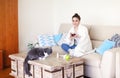 Sick woman sitting on sofa near cat Royalty Free Stock Photo