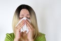 Sick woman sneezing in a handkerchief