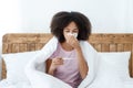 Sick woman suffers from throat and nose sore and ill from colds and flu in morning Royalty Free Stock Photo