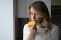 Sick woman trying to sense smell of half fresh orange, has symptom of Covid-19, loss of smell, taste Royalty Free Stock Photo